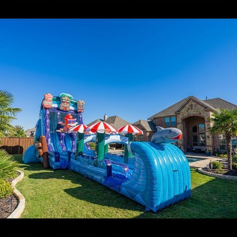 22ft Tiki Tidal Rush dual lane water slide set up in a backyard