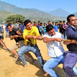 Teams pulling a tug of war rope outdoors