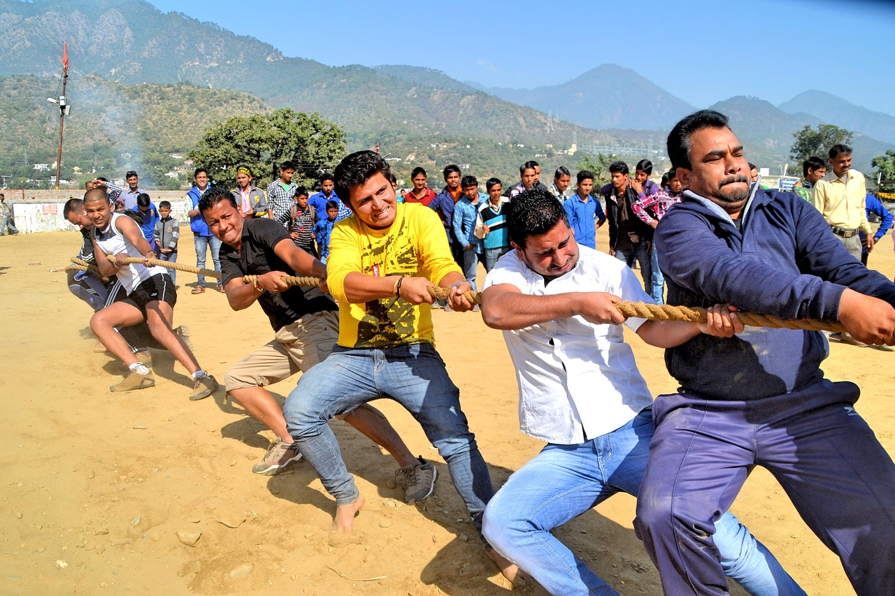 Teams pulling a tug of war rope outdoors